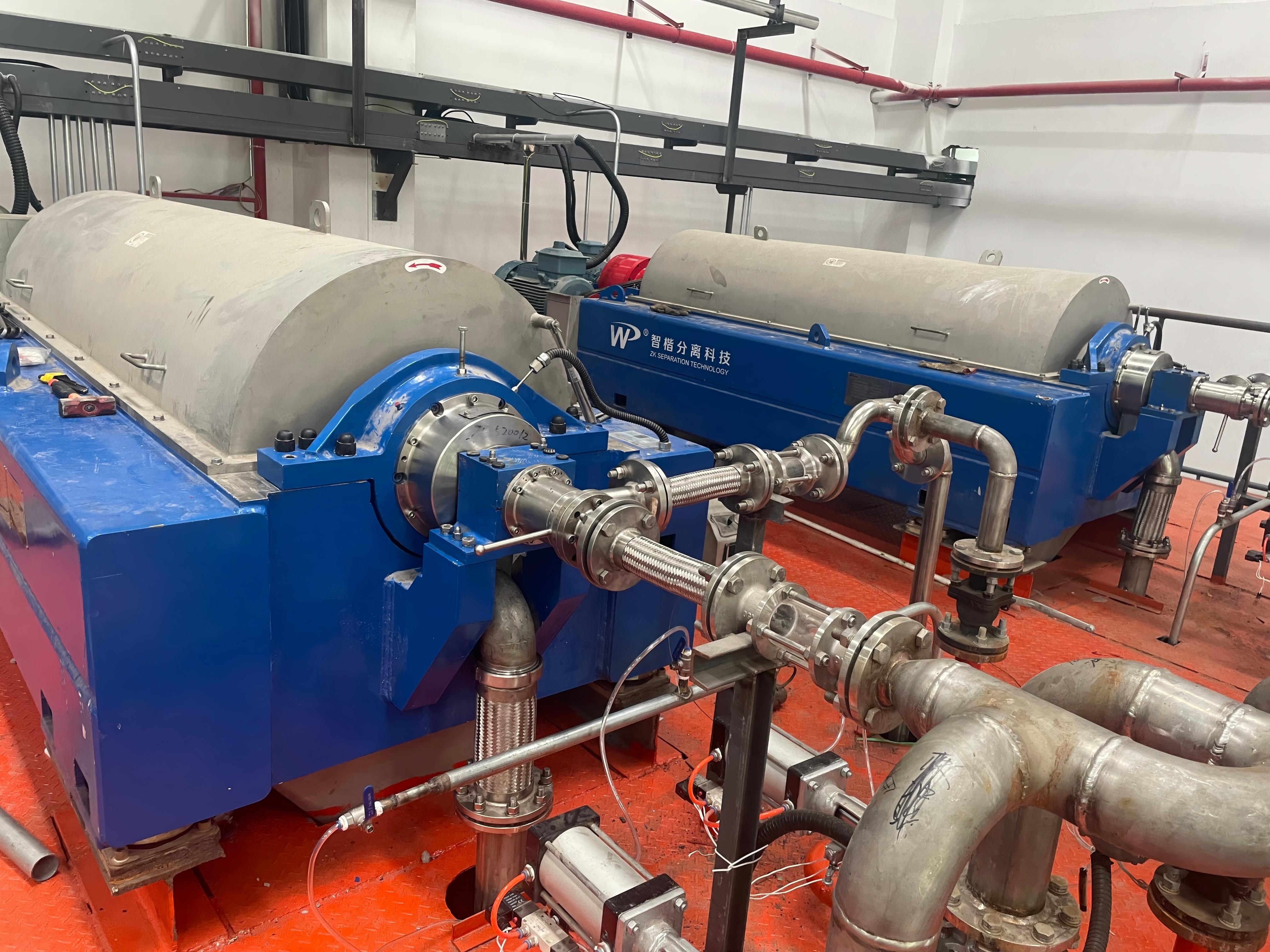 Close-up view of LWS580×2400CX three-phase decanter centrifuge installation and piping connection